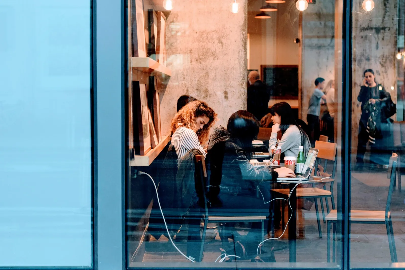 People on laptops in a busy café