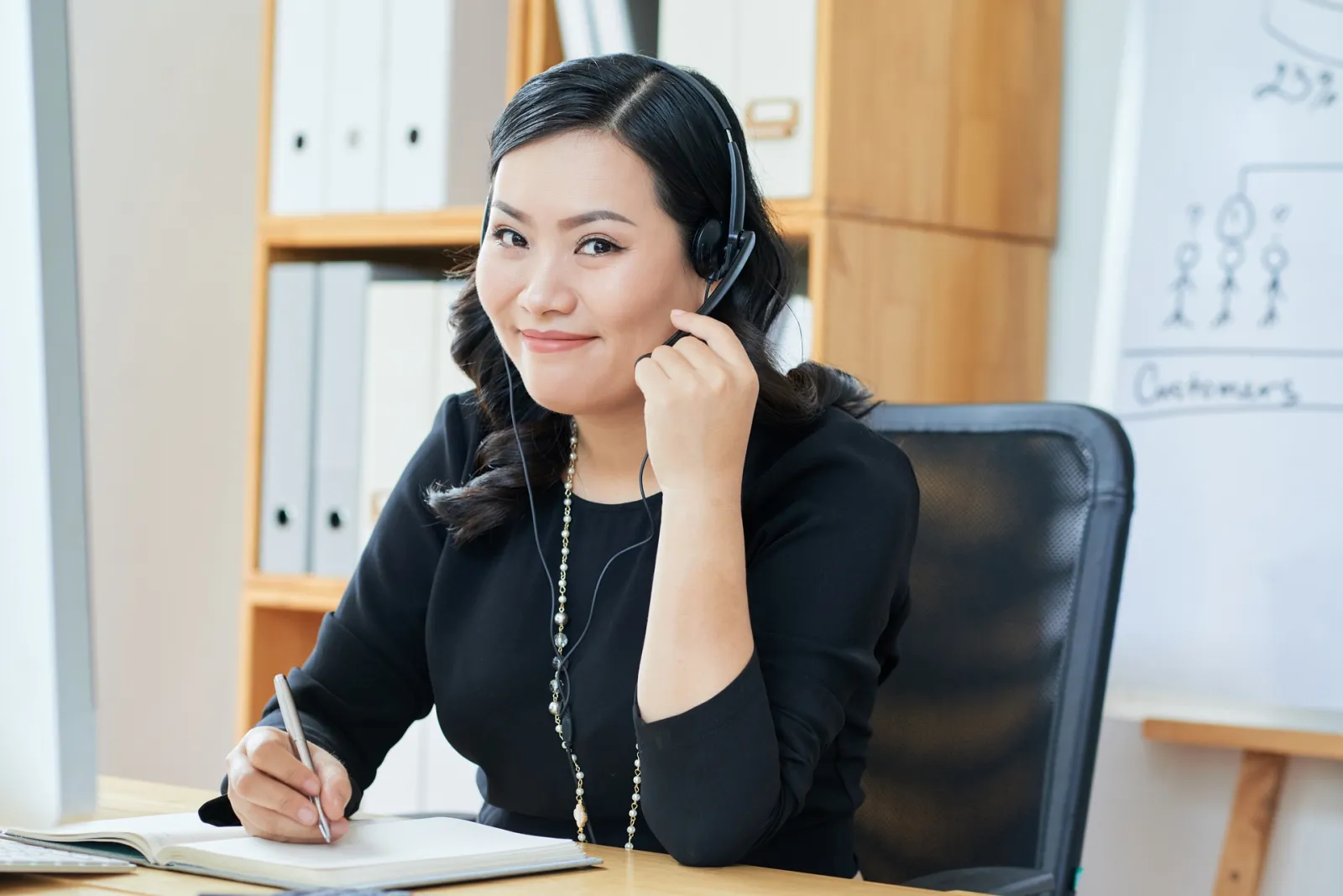 A person wearing a headset at a desk during a call